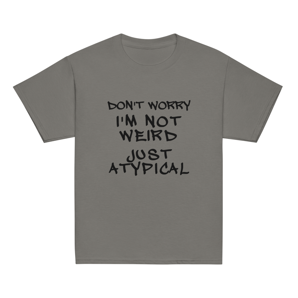 "Don't Worry I'm Not Weird Just Atypical" printed on a charcoal youth classic tee laying on a flat surface