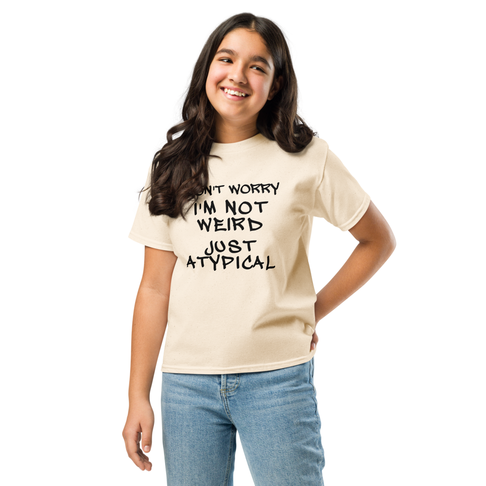 "Don't Worry I'm Not Weird Just Atypical" printed on a natural youth classic tee worn by a female