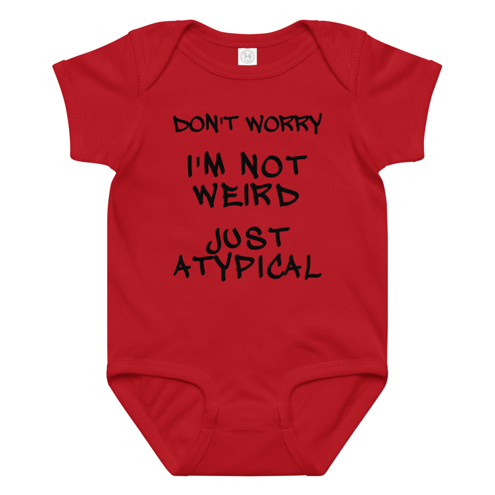 "Don't Worry I'm Not Weird Just Atypical" printed on a red baby jersey bodysuit laying on a flat surface amongst other clothes