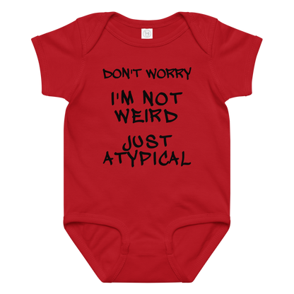"Don't Worry I'm Not Weird Just Atypical" printed on a red baby jersey bodysuit laying on a flat surface amongst other clothes