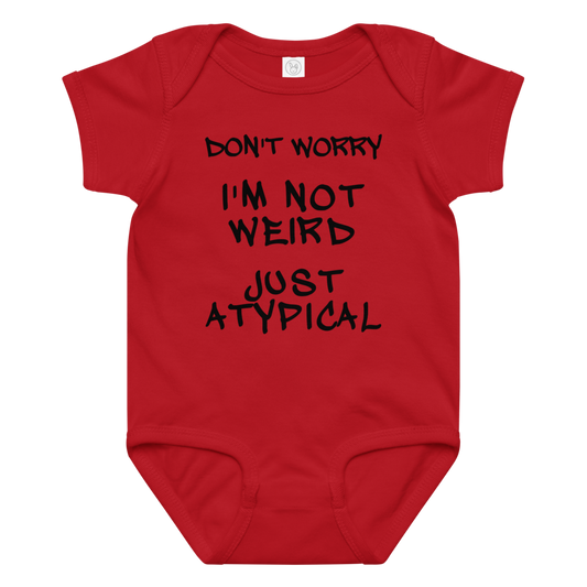 "Don't Worry I'm Not Weird Just Atypical" printed on a red baby jersey bodysuit laying on a flat surface amongst other clothes