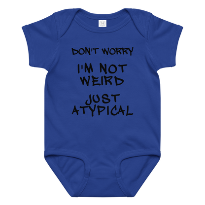 "Don't Worry I'm Not Weird Just Atypical" printed on a royal baby jersey bodysuit laying on a flat surface amongst other clothes
