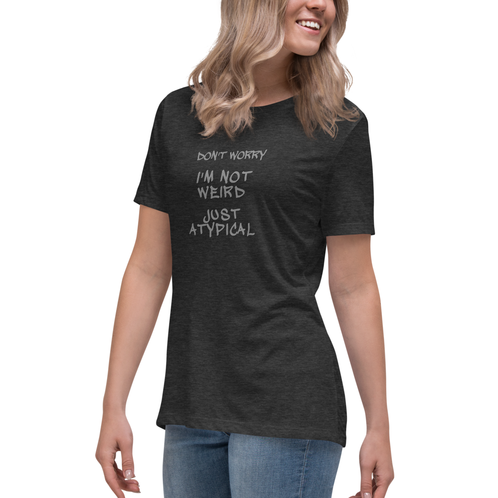 "Don't Worry I'm Not Weird Just Atypical" printed on a dark grey heather women's relaxed t-shirt worn by a female