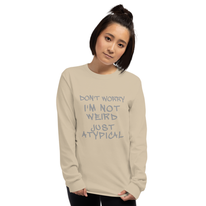 "Don't Worry I'm Not Weird Just Atypical" printed on a sand men's long sleeve shirt worn by a female