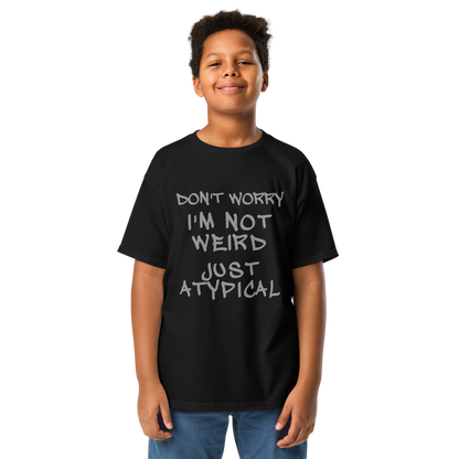 "Don't Worry I'm Not Weird Just Atypical" printed on a black youth classic tee worn by a male