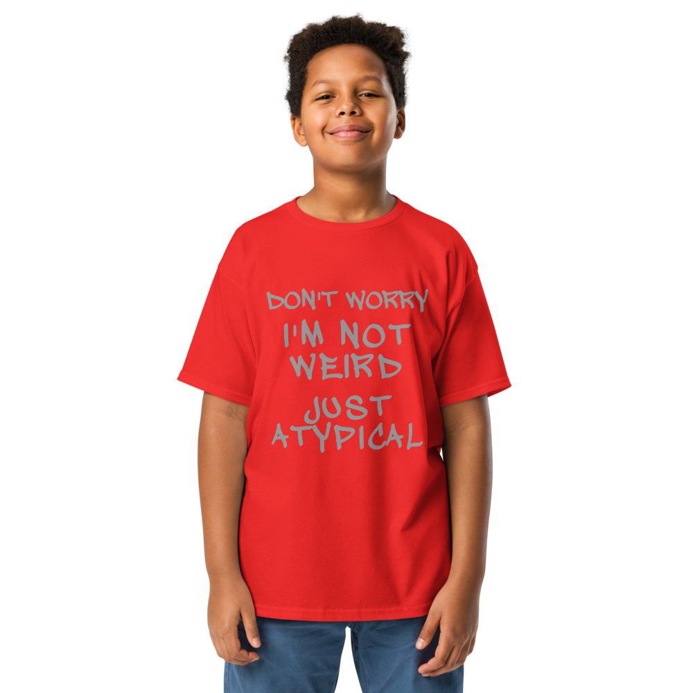 "Don't Worry I'm Not Weird Just Atypical" printed on a red youth classic tee worn by a male