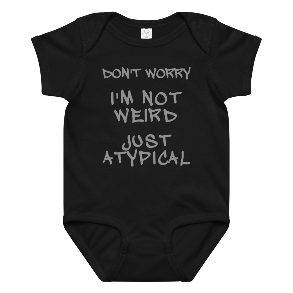 "Don't Worry I'm Not Weird Just Atypical" printed on a black baby jersey bodysuit laying on a flat surface amongst other clothes