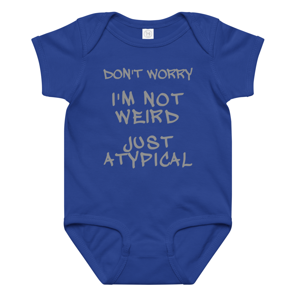"Don't Worry I'm Not Weird Just Atypical" printed on a royal baby jersey bodysuit laying on a flat surface amongst other clothes
