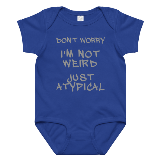 "Don't Worry I'm Not Weird Just Atypical" printed on a royal baby jersey bodysuit laying on a flat surface amongst other clothes