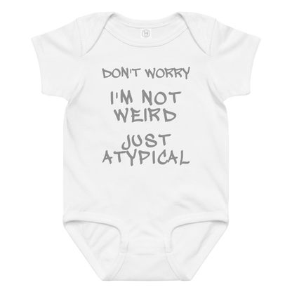 "Don't Worry I'm Not Weird Just Atypical" printed on a white baby jersey bodysuit laying on a flat surface amongst other clothes