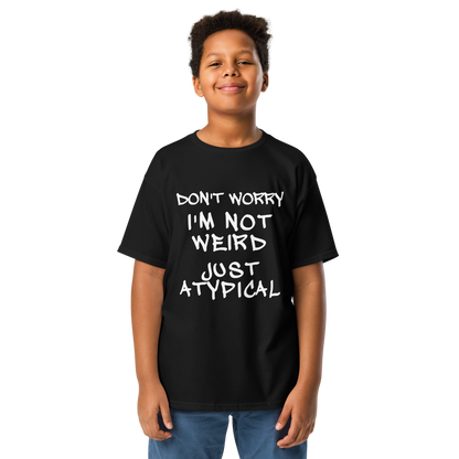 "Don't Worry I'm Not Weird Just Atypical" printed on a black youth classic tee worn by a male