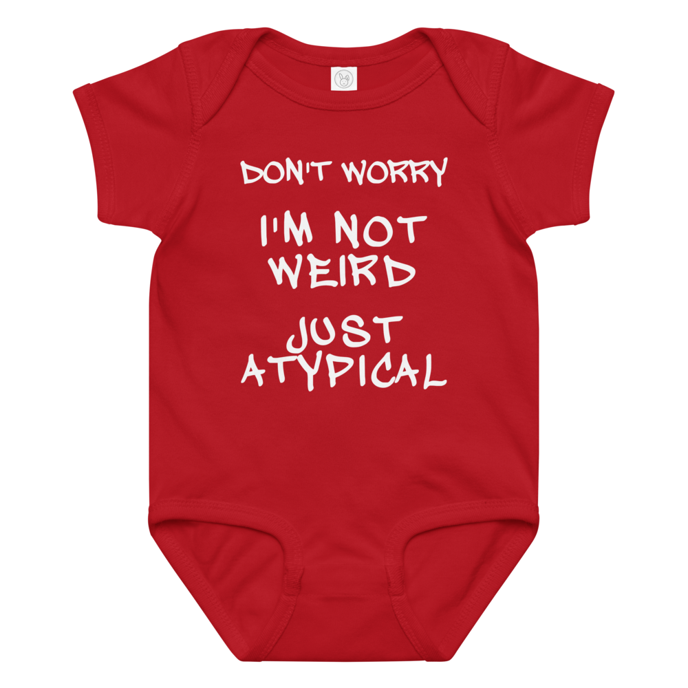 "Don't Worry I'm Not Weird Just Atypical" printed on a red baby jersey bodysuit laying on a flat surface amongst other clothes