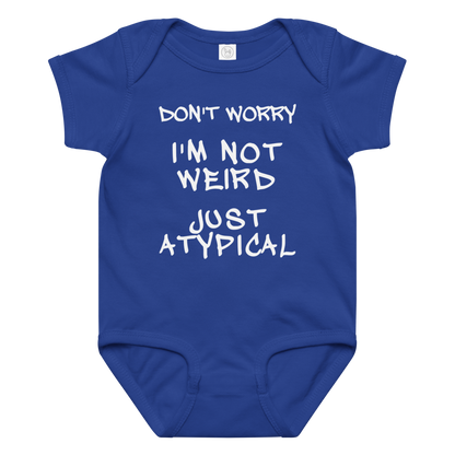 "Don't Worry I'm Not Weird Just Atypical" printed on a royal baby jersey bodysuit laying on a flat surface amongst other clothes