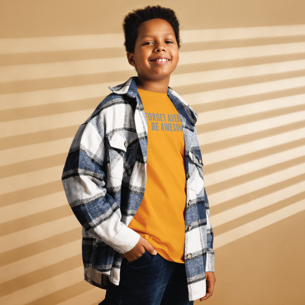 "Forget Average, Be Awesome!" printed on a gold youth classic tee worn by a male also wearing a jacket