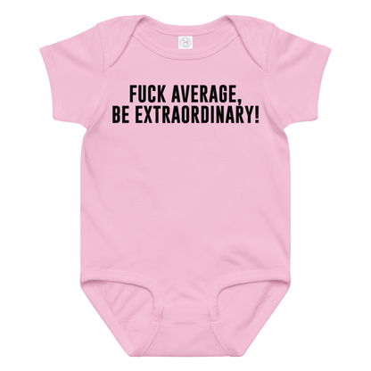 "Fuck Average, Be Extraordinary!" printed on a pink baby jersey bodysuit laying on a flat surface amongst other clothes
