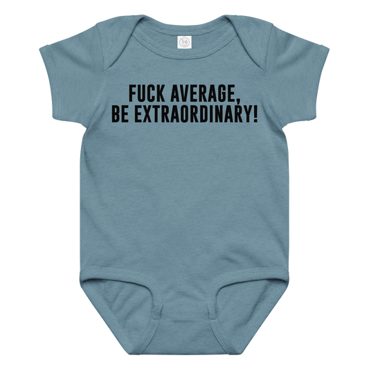 "Fuck Average, Be Extraordinary!" printed on a vintage indigo baby jersey bodysuit laying on a flat surface amongst other clothes