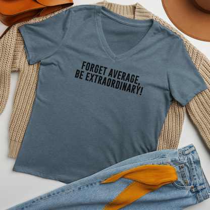 "Forget Average, Be Extraordinary!" printed on a heather slate women's relaxed v-neck t-shirt laying on a flat surface amongst other clothes