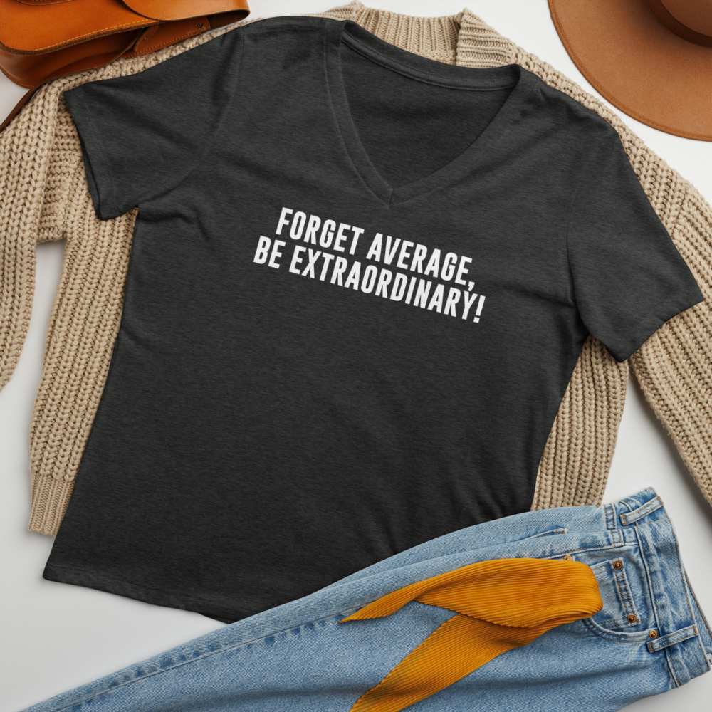 "Forget Average, Be Extraordinary!" printed on a dark grey heather women's relaxed v-neck t-shirt laying on a flat surface amongst other clothes