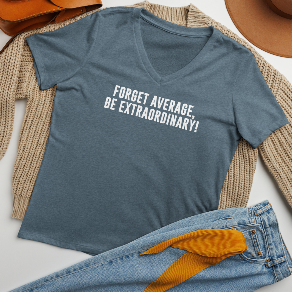 "Forget Average, Be Extraordinary!" printed on a heather slate women's relaxed v-neck t-shirt laying on a flat surface amongst other clothes