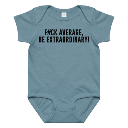 "F#Ck Average, Be Extraordinary!" printed on a vintage indigo baby jersey bodysuit laying on a flat surface amongst other clothes