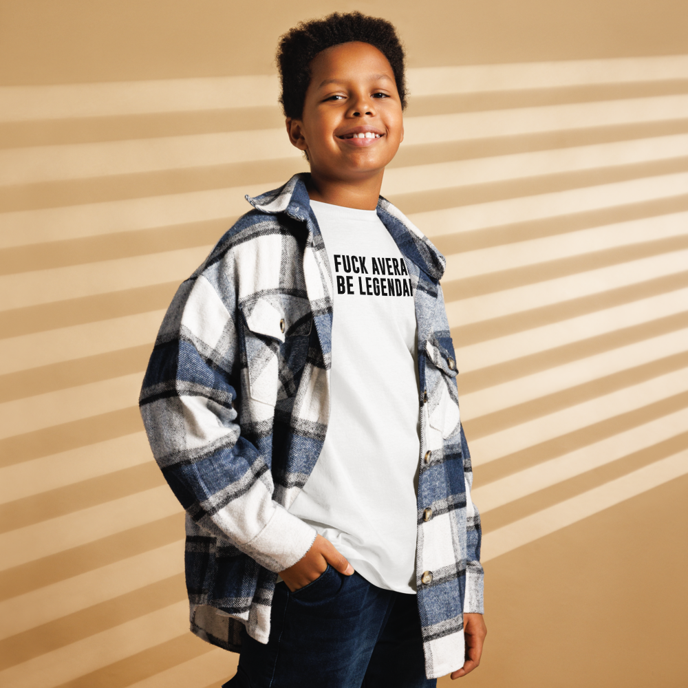 "Fuck Average, Be Legendary!" printed on a white youth classic tee worn by a male also wearing a jacket