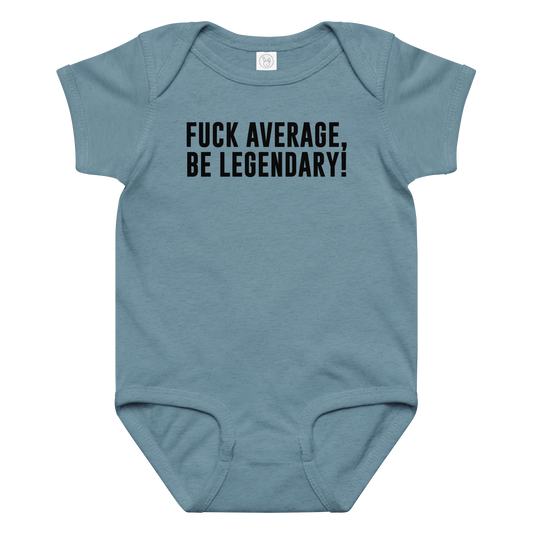 "Fuck Average, Be Legendary!" printed on a vintage indigo baby jersey bodysuit laying on a flat surface amongst other clothes