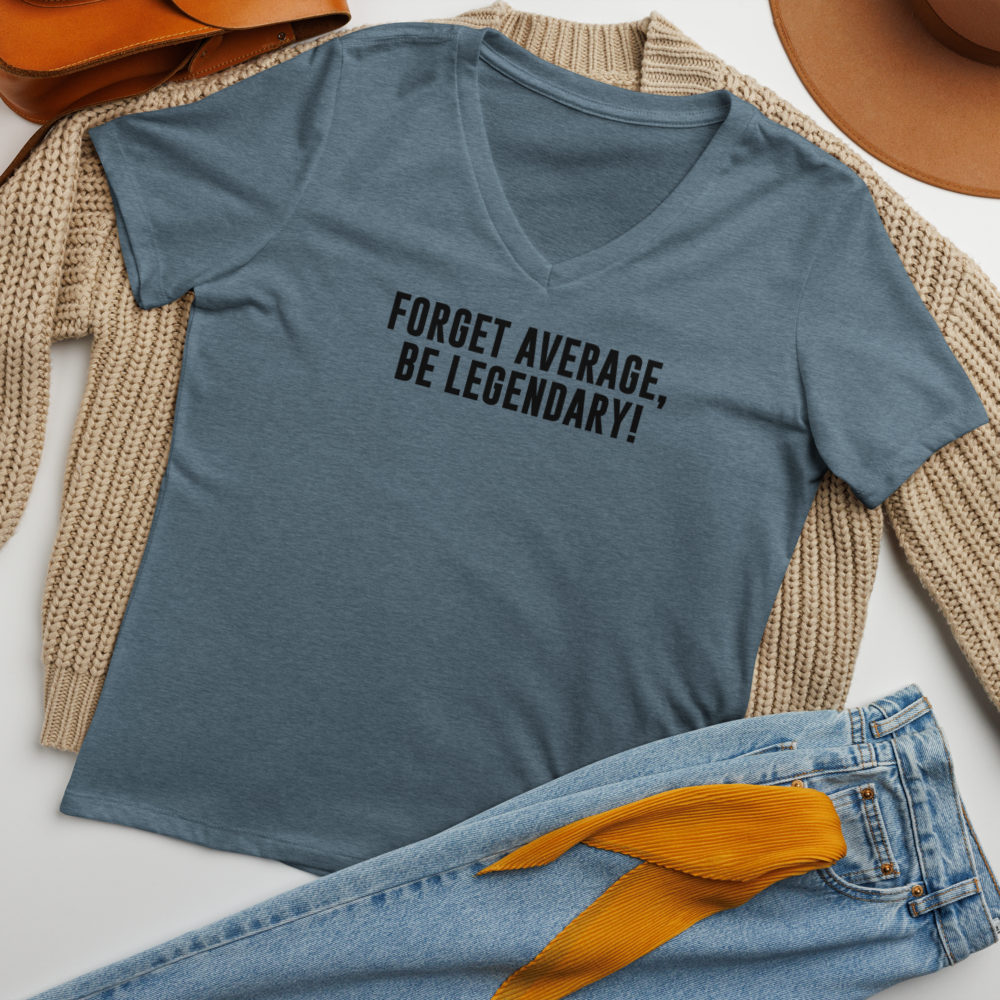 "Forget Average, Be Legendary!" printed on a heather slate women's relaxed v-neck t-shirt laying on a flat surface amongst other clothes
