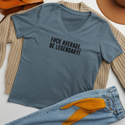 "F#Ck Average, Be Legendary!" printed on a heather slate women's relaxed v-neck t-shirt laying on a flat surface amongst other clothes