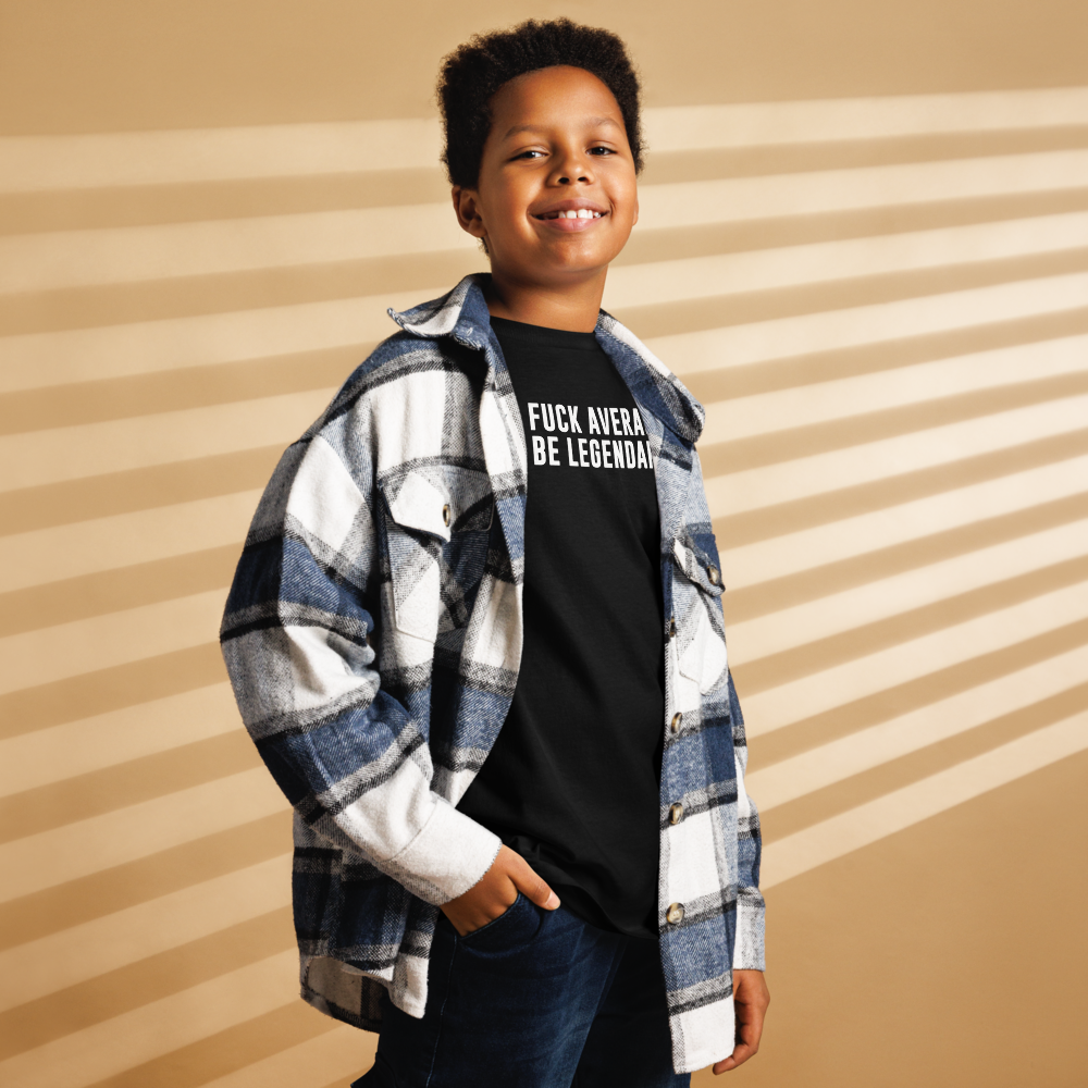 "Fuck Average, Be Legendary!" printed on a black youth classic tee worn by a male also wearing a jacket