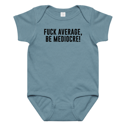 "Fuck Average, Be Mediocre!" printed on a vintage indigo baby jersey bodysuit laying on a flat surface amongst other clothes