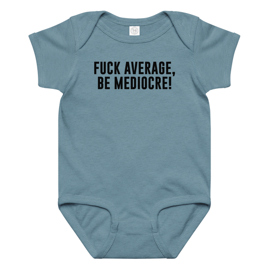 "Fuck Average, Be Mediocre!" printed on a vintage indigo baby jersey bodysuit laying on a flat surface amongst other clothes