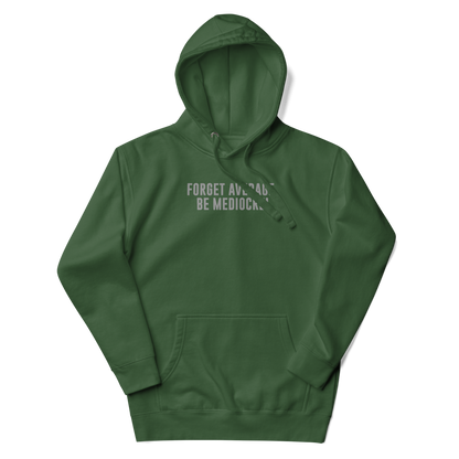 "Forget Average, Be Mediocre!" printed on a forest green unisex hoodie laying on a flat surface with the hood up