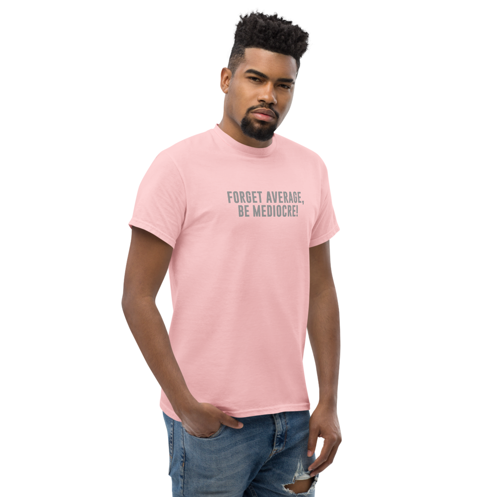 "Forget Average, Be Mediocre!" printed on a light pink unisex classic tee worn by a male