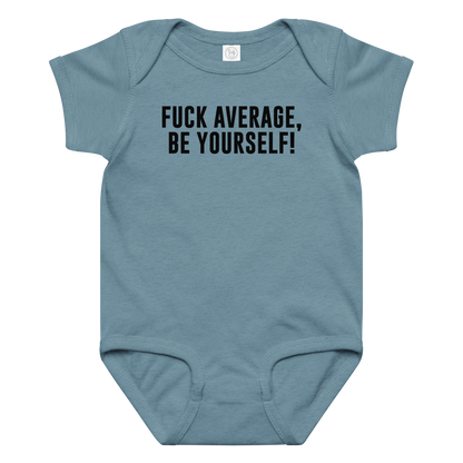 "Fuck Average, Be Yourself!" printed on a vintage indigo baby jersey bodysuit laying on a flat surface amongst other clothes