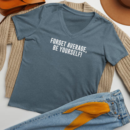"Forget Average, Be Yourself!" printed on a heather slate women's relaxed v-neck t-shirt laying on a flat surface amongst other clothes