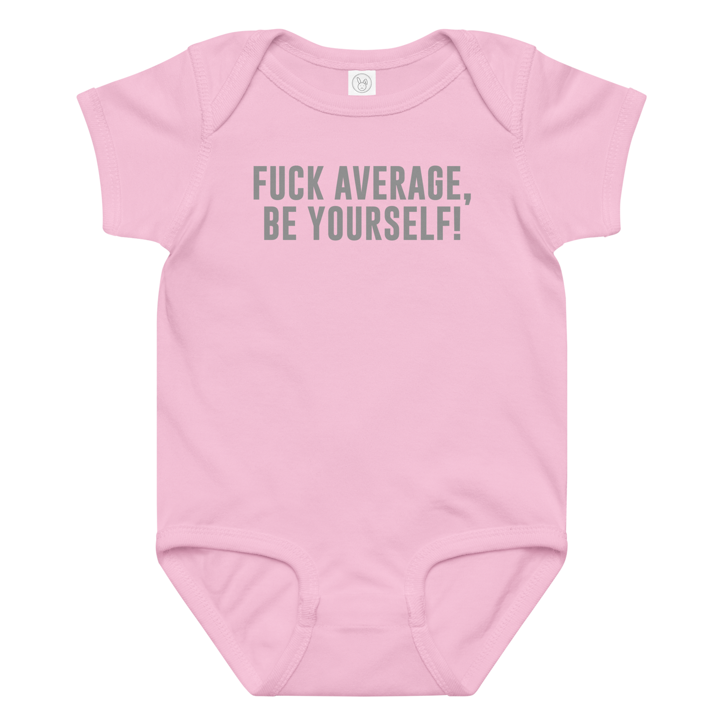 "Fuck Average, Be Yourself!" printed on a pink baby jersey bodysuit laying on a flat surface amongst other clothes