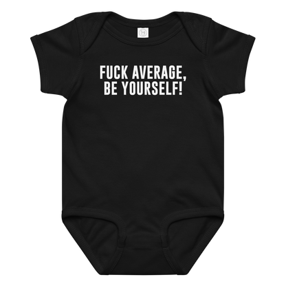 "Fuck Average, Be Yourself!" printed on a black baby jersey bodysuit laying on a flat surface amongst other clothes