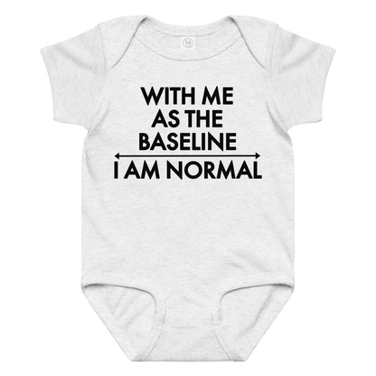 "With me as the baseline, I am normal" printed on a ash baby jersey bodysuit laying on a flat surface amongst other clothes