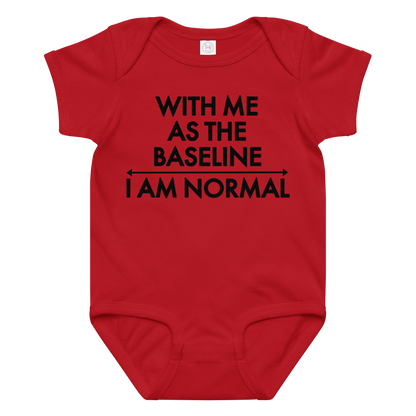 "With me as the baseline, I am normal" printed on a red baby jersey bodysuit laying on a flat surface amongst other clothes