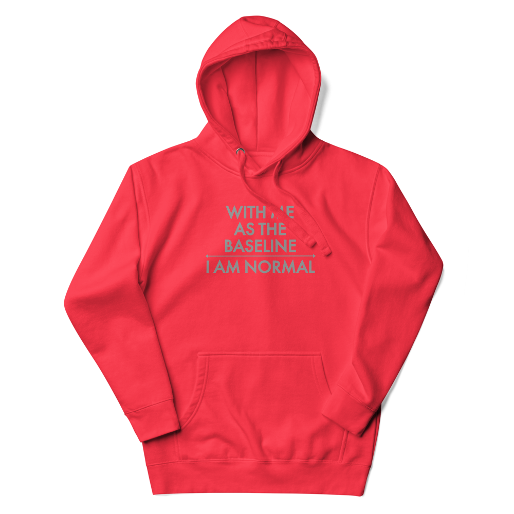 "With me as the baseline, I am normal" printed on a team red unisex hoodie laying on a flat surface with the hood up