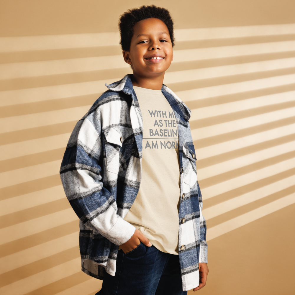 "With me as the baseline, I am normal" printed on a natural youth classic tee worn by a male also wearing a jacket