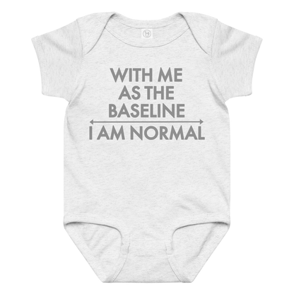 "With me as the baseline, I am normal" printed on a ash baby jersey bodysuit laying on a flat surface amongst other clothes