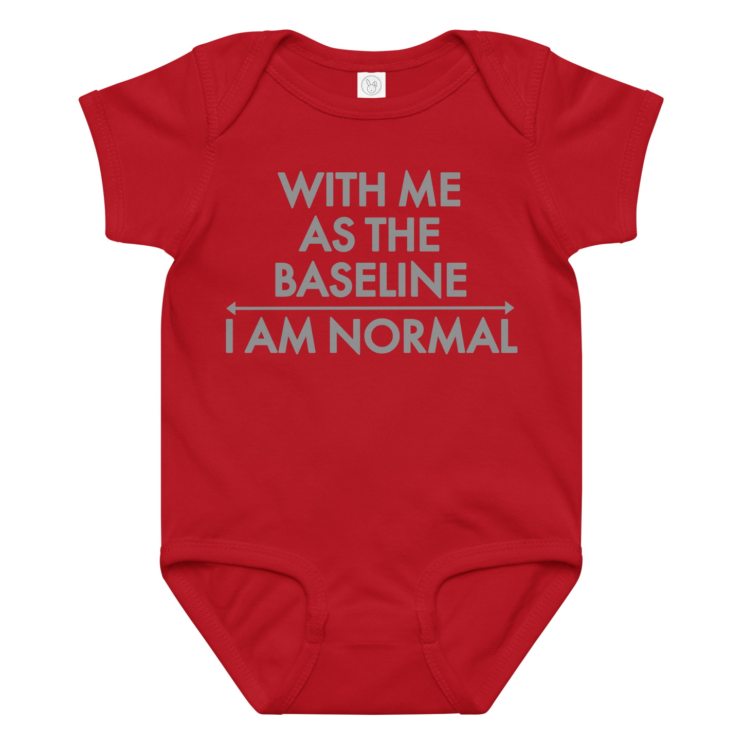 "With me as the baseline, I am normal" printed on a red baby jersey bodysuit laying on a flat surface amongst other clothes
