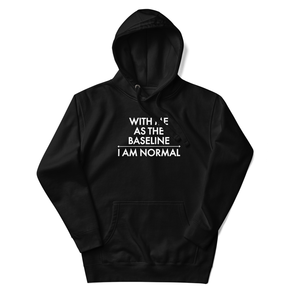 "With me as the baseline, I am normal" printed on a black unisex hoodie laying on a flat surface with the hood up