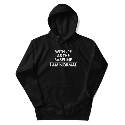 "With me as the baseline, I am normal" printed on a black unisex hoodie laying on a flat surface with the hood up