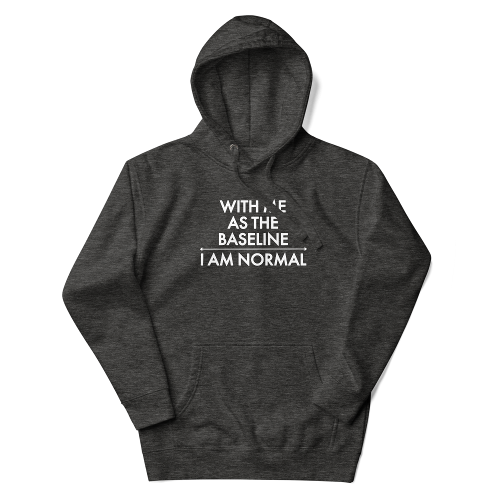 "With me as the baseline, I am normal" printed on a charcoal heather unisex hoodie laying on a flat surface with the hood up