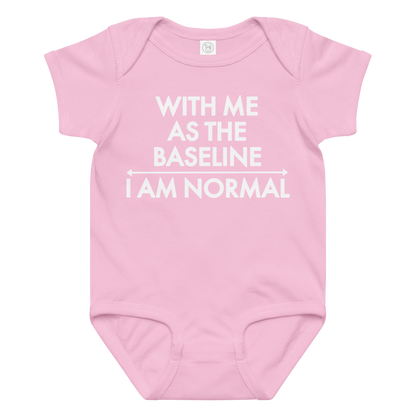 "With me as the baseline, I am normal" printed on a pink baby jersey bodysuit laying on a flat surface amongst other clothes