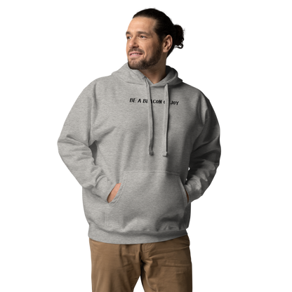 "Be a beacon of joy" printed on a carbon grey unisex hoodie worn by a male