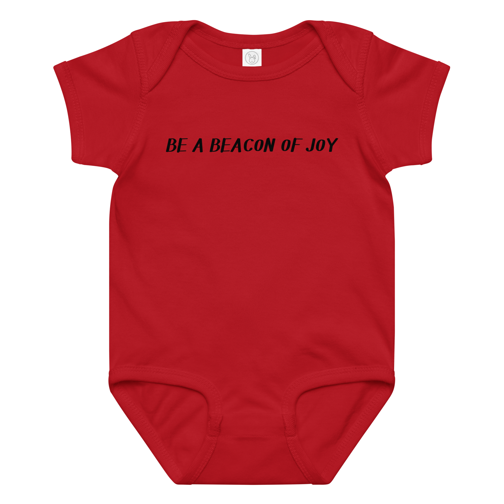 "Be a beacon of joy" printed on a red baby jersey bodysuit laying on a flat surface amongst other clothes
