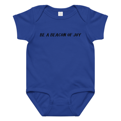 "Be a beacon of joy" printed on a royal baby jersey bodysuit laying on a flat surface amongst other clothes